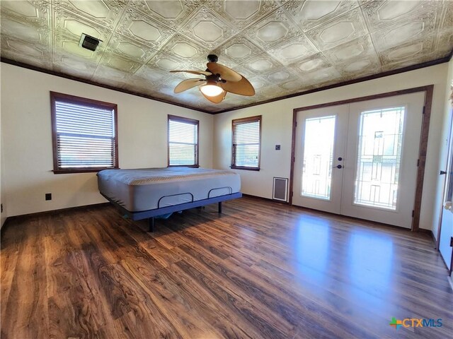 bedroom with access to outside, multiple windows, french doors, and dark wood-type flooring