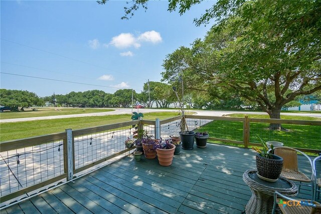 wooden terrace featuring a lawn