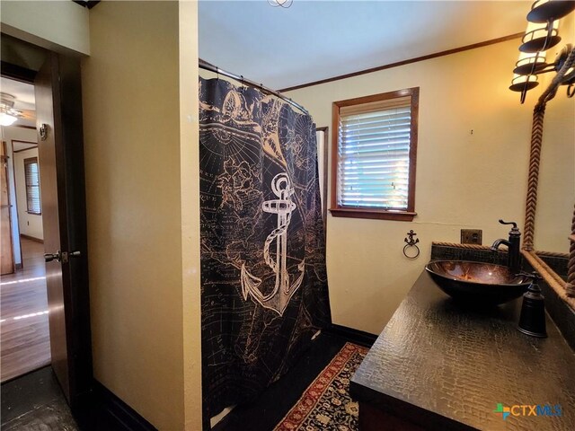 bathroom with vanity, ornamental molding, and walk in shower