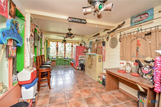 interior space with a workshop area, ceiling fan, and tile patterned floors