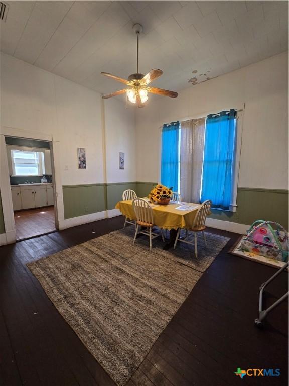 dining space featuring visible vents, wood-type flooring, and a ceiling fan