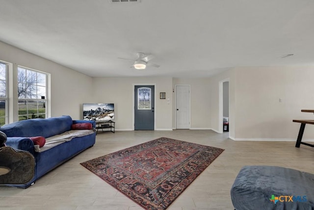 living room with ceiling fan, wood finished floors, and baseboards