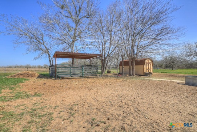 view of yard featuring a rural view and an outbuilding