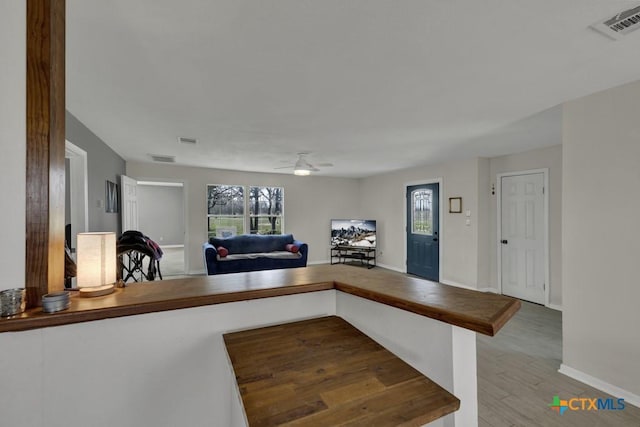 kitchen featuring butcher block counters, visible vents, open floor plan, and wood finished floors