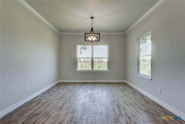 unfurnished room featuring ornamental molding, light hardwood / wood-style flooring, and a chandelier