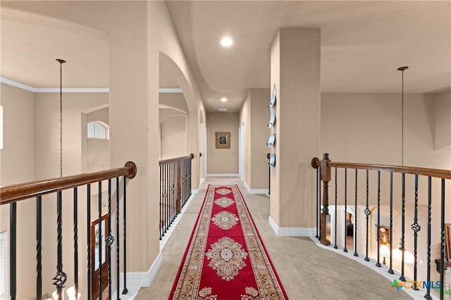 hallway with recessed lighting, an upstairs landing, arched walkways, and carpet floors