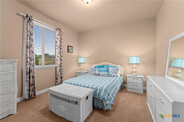 bedroom featuring light carpet and baseboards