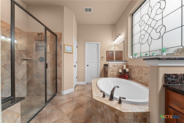 full bath featuring a shower stall, vanity, visible vents, baseboards, and a garden tub