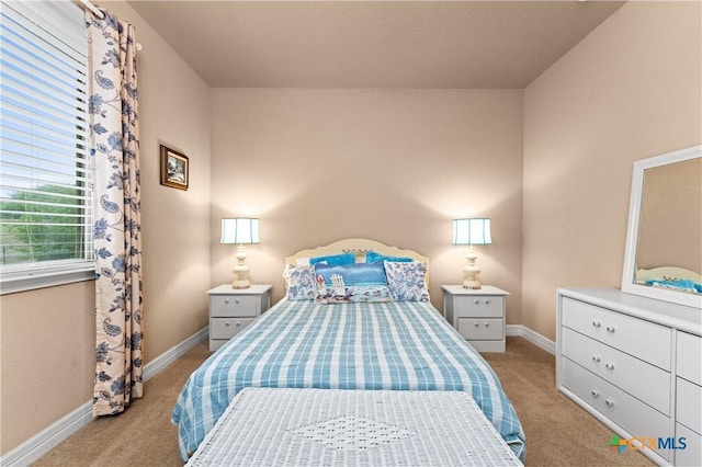 bedroom featuring light carpet and baseboards