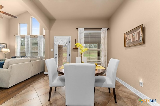 dining room featuring tile patterned flooring, a ceiling fan, lofted ceiling, and baseboards