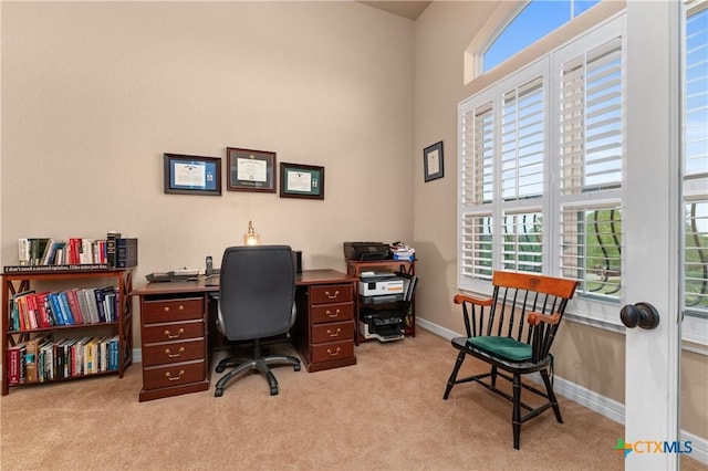 home office featuring baseboards, light carpet, and a healthy amount of sunlight