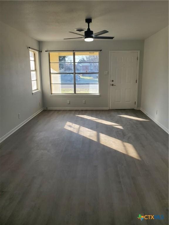 interior space featuring ceiling fan, baseboards, and wood finished floors