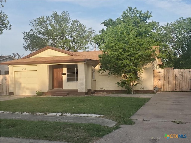 single story home featuring stucco siding, a front yard, fence, an attached garage, and concrete driveway