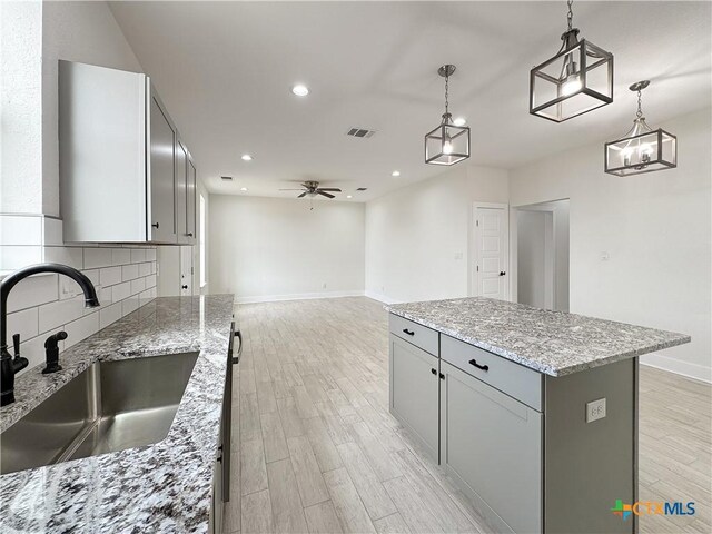 1637 Bob White Dr, Spring Branch, TX 78070 - kitchen with a sink, gray cabinetry, light wood-type flooring, baseboards, and recessed lighting