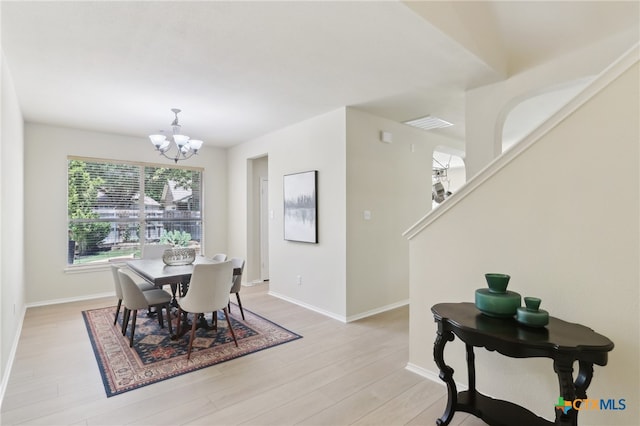 19303 Anna Kate Ct, Pflugerville, TX 78660 - dining room with a chandelier, light wood-style floors, baseboards, and stairway
