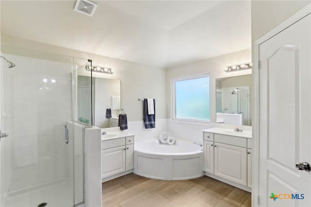 19303 Anna Kate Ct, Pflugerville, TX 78660 - bathroom with a shower stall, two vanities, a bath, and wood finished floors