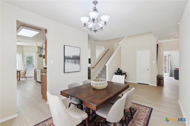 19303 Anna Kate Ct, Pflugerville, TX 78660 - dining room with a chandelier, stairs, light wood-style floors, and baseboards