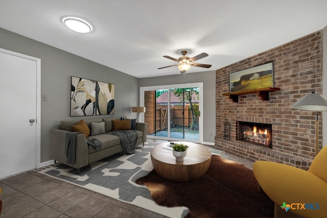 tiled living room with a brick fireplace and ceiling fan