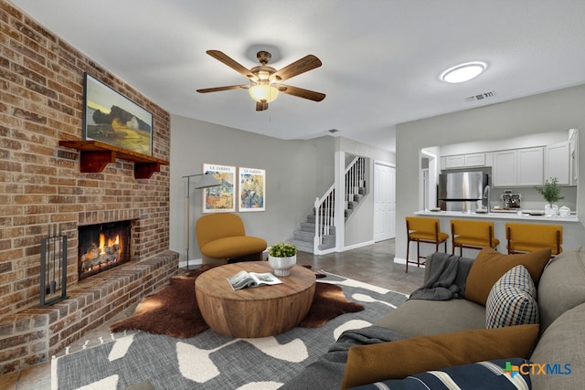 living room with sink, ceiling fan, and a fireplace