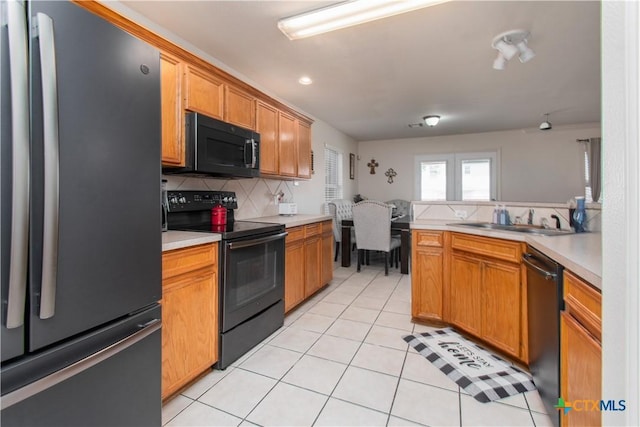 2409 Eppinette Dr, Killeen, TX 76542 - kitchen with black appliances, a sink, backsplash, light countertops, and light tile patterned flooring