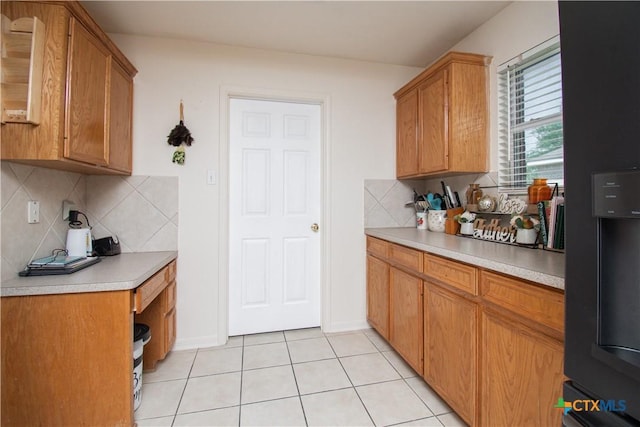 2409 Eppinette Dr, Killeen, TX 76542 - kitchen with refrigerator with ice dispenser, light countertops, light tile patterned floors, and brown cabinets