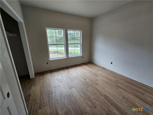 1420 Canyon Bnd, Canyon Lake, TX 78133 - unfurnished bedroom with wood finished floors and a textured wall