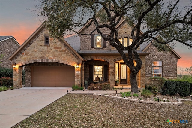 182 Emma Loop, Austin, TX 78737 - french provincial home with driveway, an attached garage, and stone siding