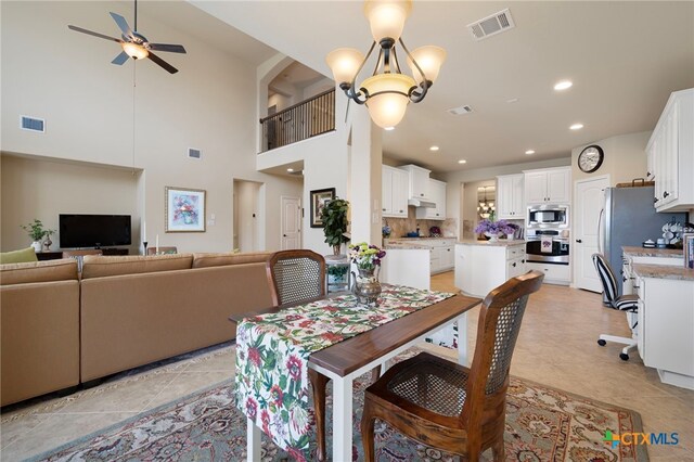182 Emma Loop, Austin, TX 78737 - dining space with a ceiling fan, recessed lighting, a high ceiling, light tile patterned flooring, and a chandelier