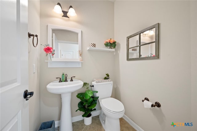 182 Emma Loop, Austin, TX 78737 - half bathroom with toilet, tile patterned floors, baseboards, and a sink