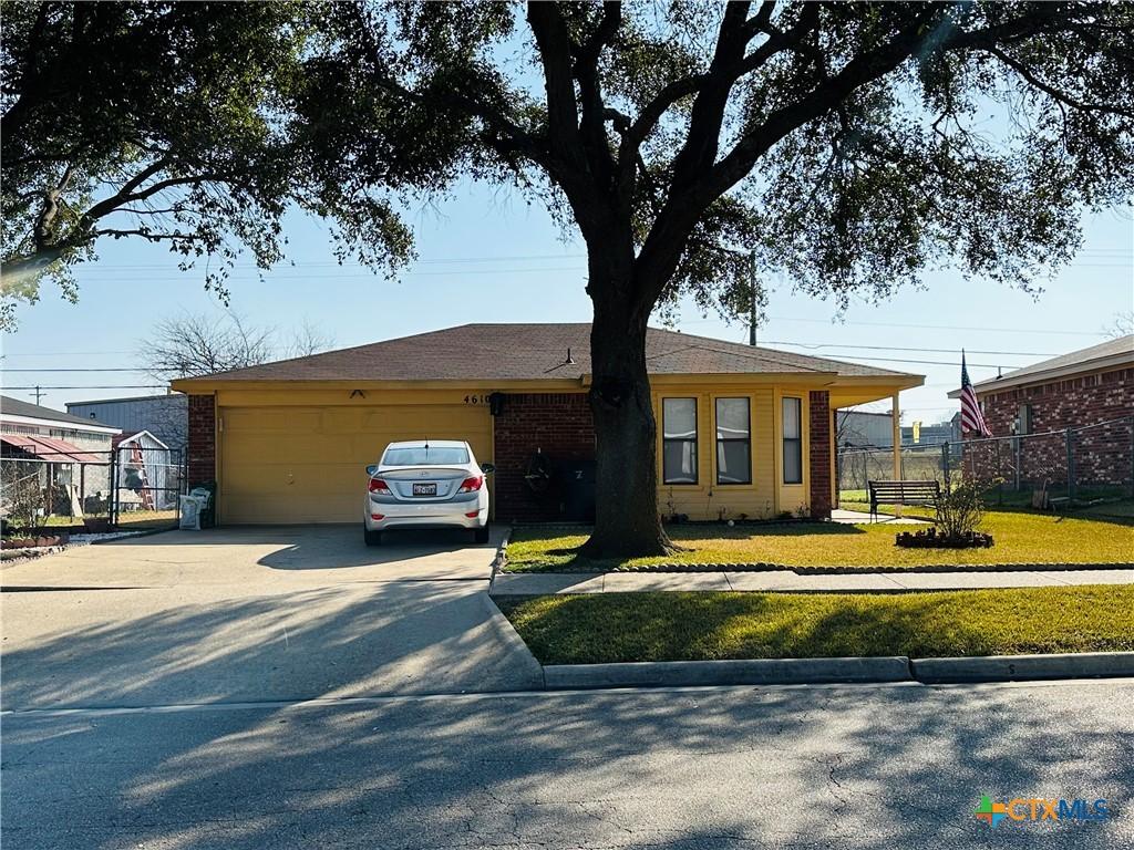 ranch-style house featuring a garage and a front yard