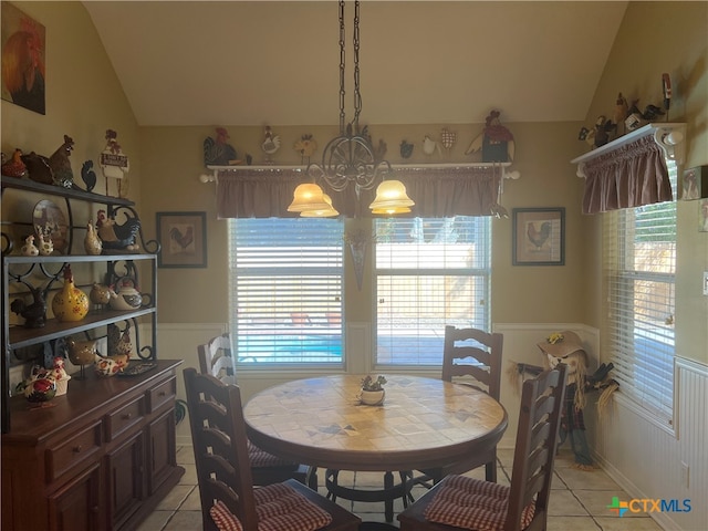 tiled dining room with an inviting chandelier and lofted ceiling