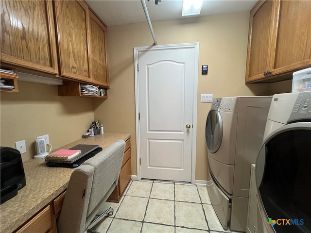 laundry area with washer and clothes dryer, cabinets, and light tile patterned flooring