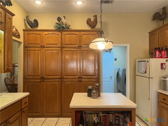 kitchen with hanging light fixtures, light tile patterned floors, and white refrigerator