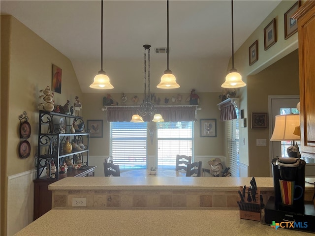 kitchen featuring an inviting chandelier, decorative light fixtures, and vaulted ceiling