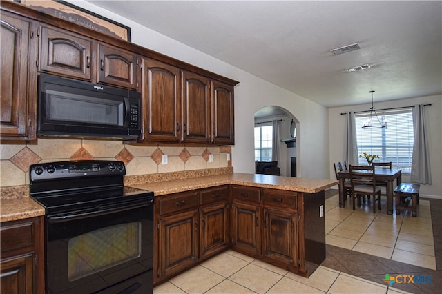 kitchen featuring black appliances, tasteful backsplash, kitchen peninsula, and a notable chandelier