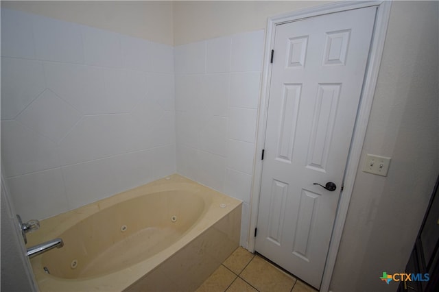 bathroom with a bath and tile patterned flooring