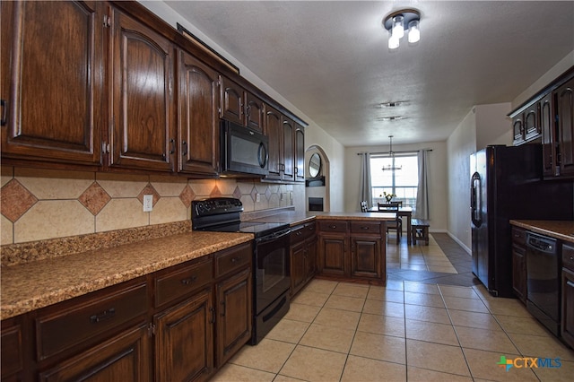 kitchen featuring black appliances, backsplash, dark brown cabinets, light tile patterned floors, and pendant lighting