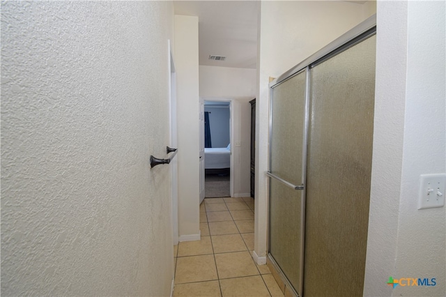 bathroom featuring tile patterned floors and a shower with door