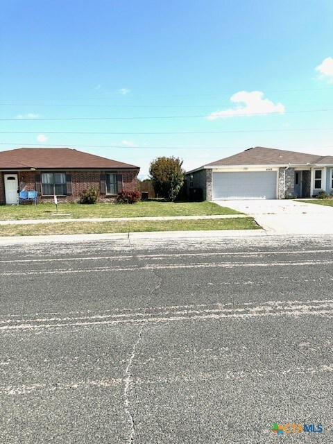 4505 Mustang Dr, Killeen, TX 76549 - ranch-style home featuring brick siding, an attached garage, a front lawn, and driveway