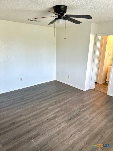 4505 Mustang Dr, Killeen, TX 76549 - unfurnished room featuring a ceiling fan, dark wood-type flooring, a textured ceiling, and visible vents