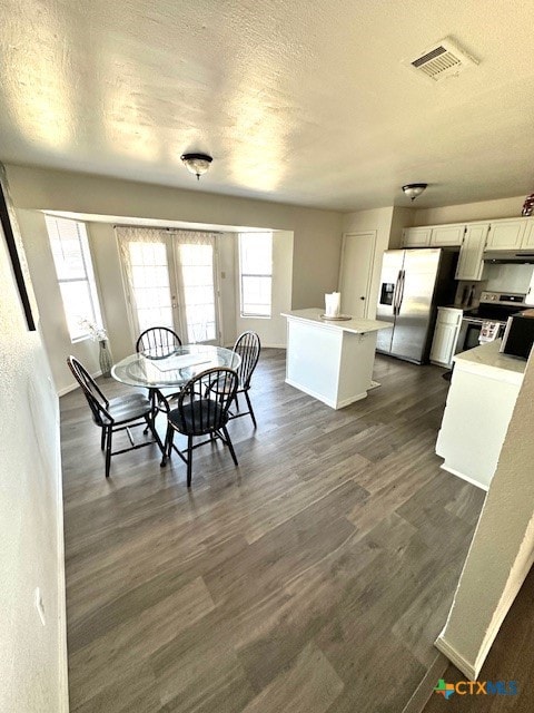 dining space featuring dark hardwood / wood-style flooring and a textured ceiling