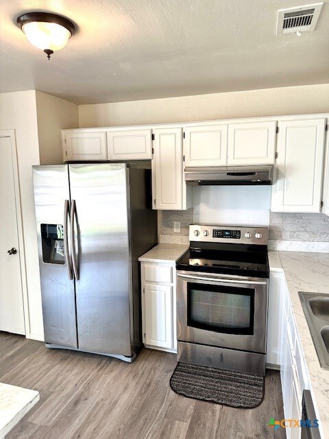 4505 Mustang Dr, Killeen, TX 76549 - kitchen featuring visible vents, under cabinet range hood, light wood-type flooring, and appliances with stainless steel finishes