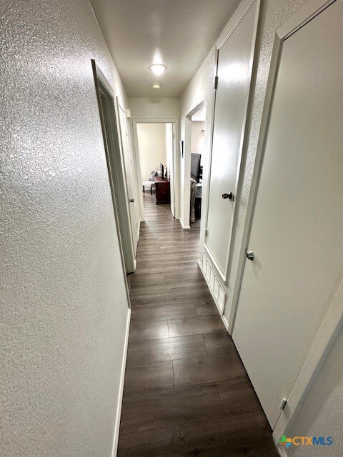 4505 Mustang Dr, Killeen, TX 76549 - hall with a textured wall and dark wood-style floors