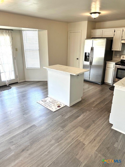 4505 Mustang Dr, Killeen, TX 76549 - kitchen featuring under cabinet range hood, appliances with stainless steel finishes, a center island, and dark wood-style flooring