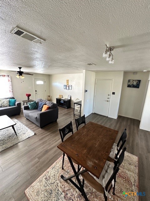 dining area featuring hardwood / wood-style floors, a textured ceiling, and ceiling fan