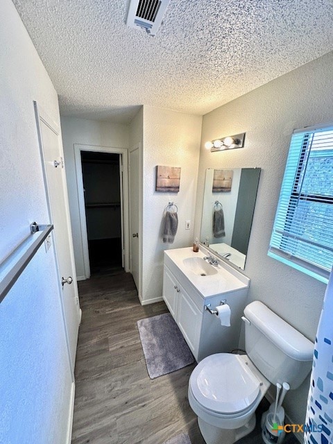 bathroom featuring toilet, vanity, a textured ceiling, and hardwood / wood-style flooring