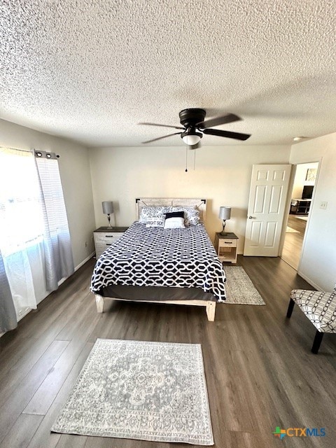 bedroom with ceiling fan, wood-type flooring, and a textured ceiling