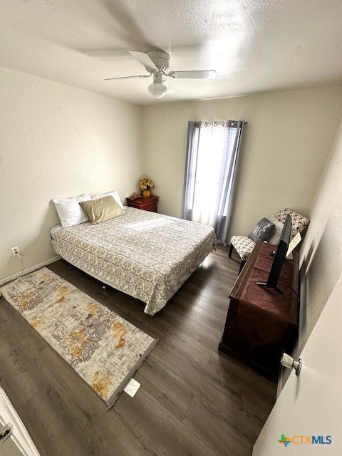 bedroom with ceiling fan, dark hardwood / wood-style floors, and a textured ceiling