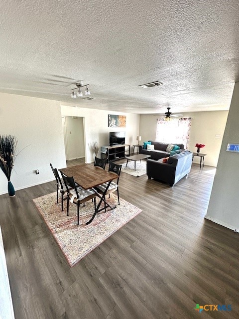 dining space with ceiling fan, a textured ceiling, and dark hardwood / wood-style flooring