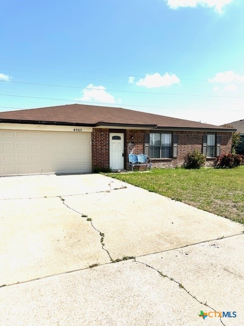 4505 Mustang Dr, Killeen, TX 76549 - ranch-style house with brick siding, an attached garage, a front yard, and driveway